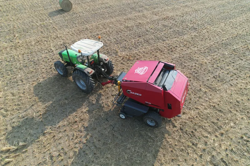 Overhead view of the FM1280 and tractor with their shadows on the stubble
