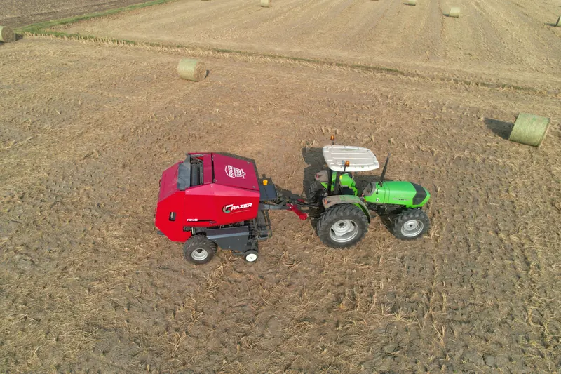 FM1280 working between finished round bales